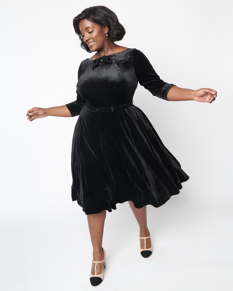 Front of a model wearing a size XL Unique Vintage Black Velvet Faux Bow Devon Swing Dress in Black by Unique Vintage. | dia_product_style_image_id:316979